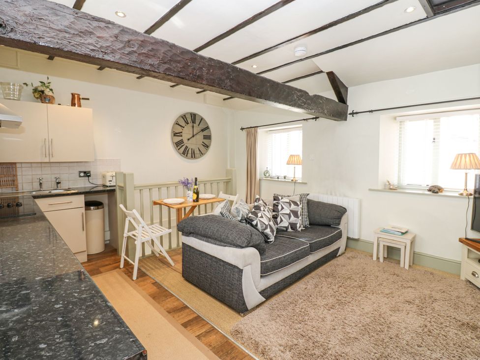 A living room with a sofa and dining table at In & Out Cottage Leyburn