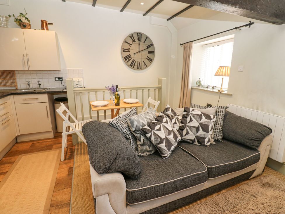A living room with a couch and dining table at In & Out Cottage in Leyburn