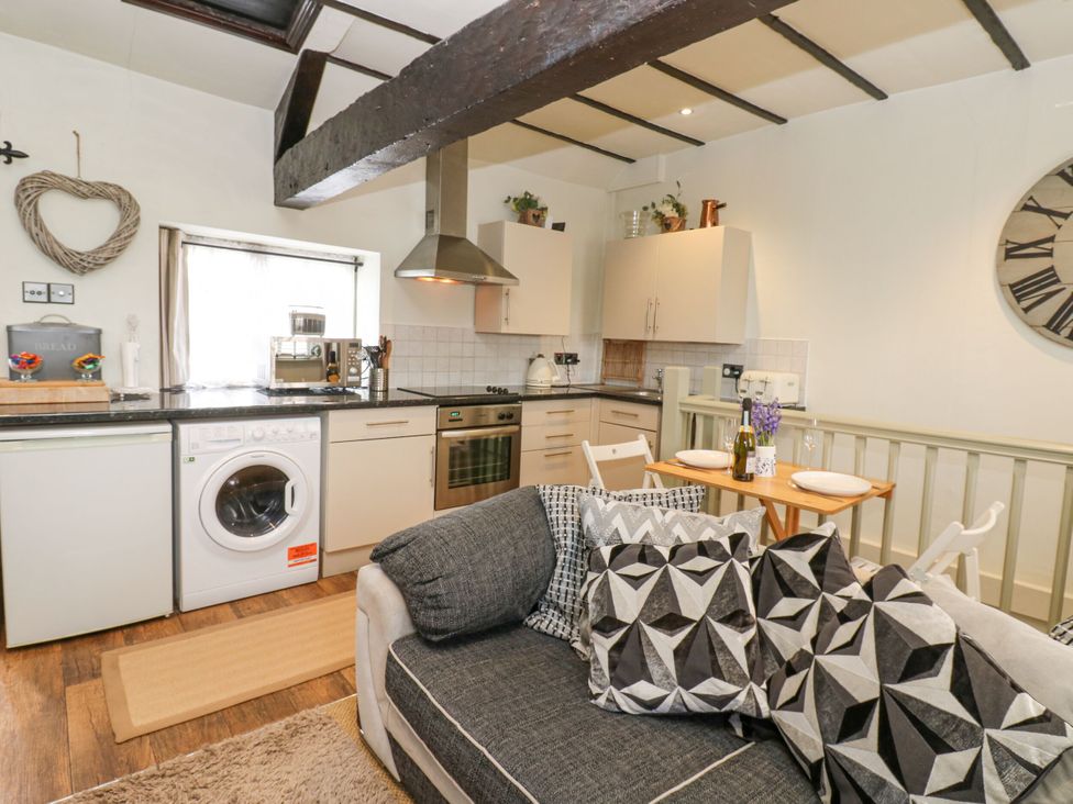 A kitchen with appliances and dining area at In & Out Cottage Leyburn
