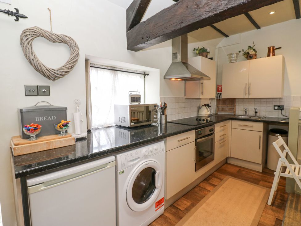 A kitchen with a washing machine and oven at In & Out Cottage Leyburn