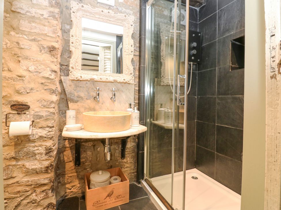 A bathroom with a sink and shower at In & Out Cottage in Leyburn