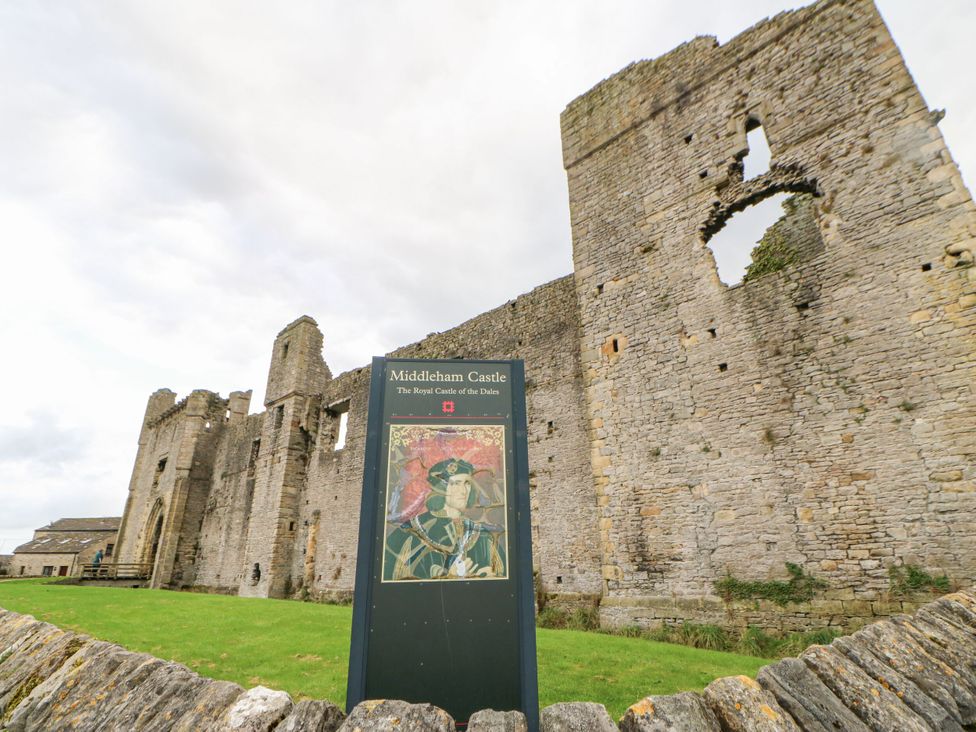 Middleham Castle ruins with a sign at the foreground in Leyburn