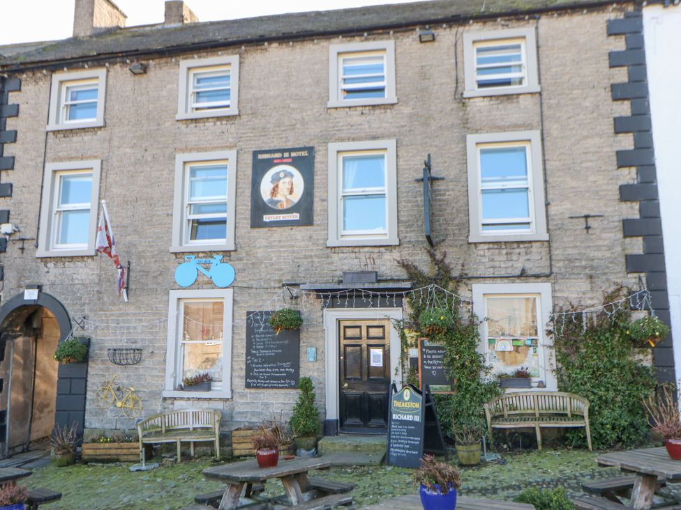 A building with benches and plants outside at In & Out Cottage Leyburn