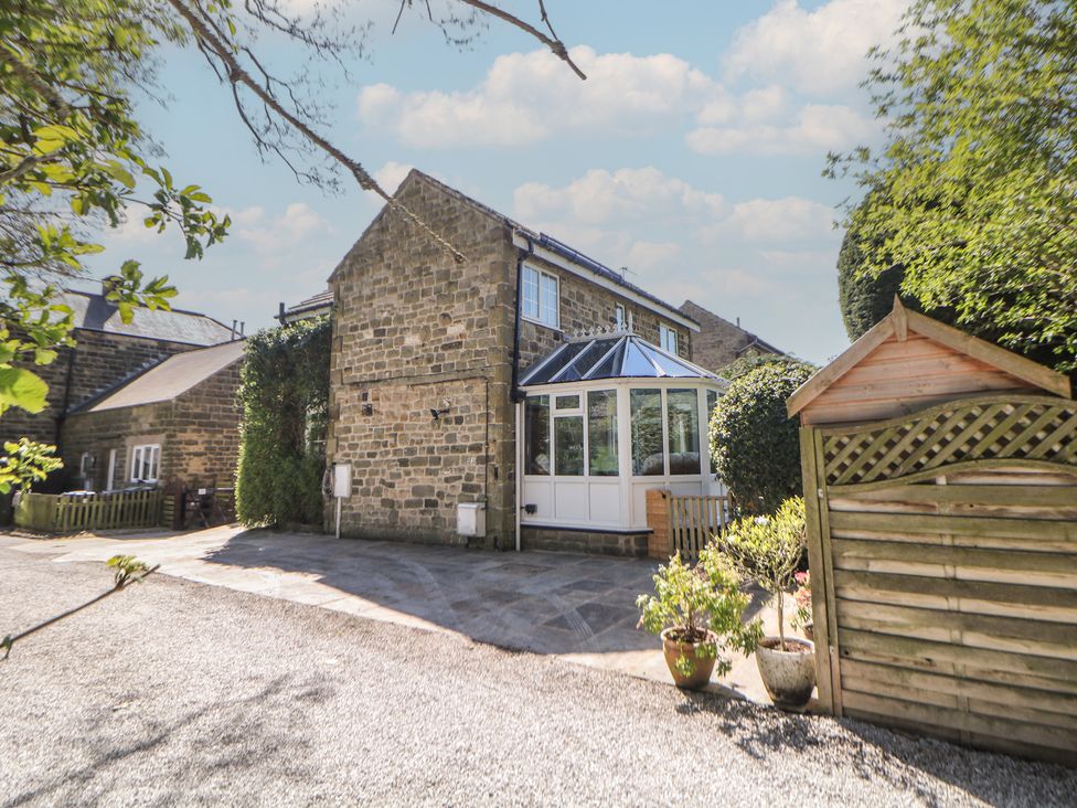 A house with a conservatory and gravel driveway at Pine Cottage
