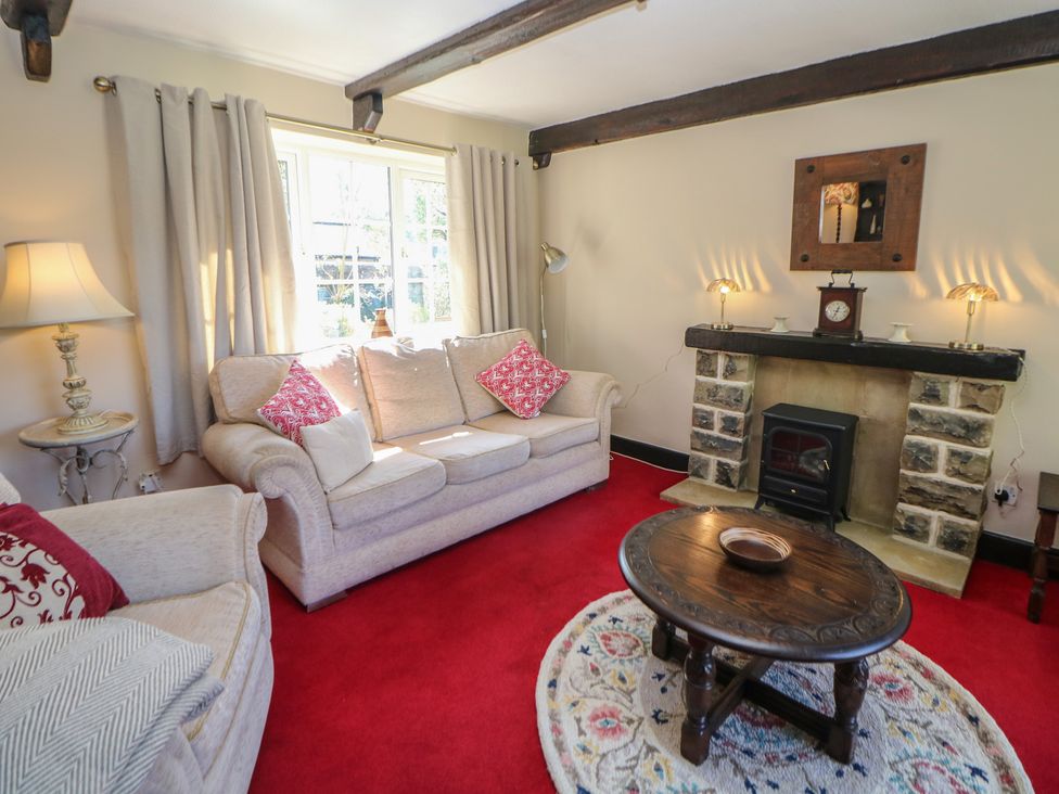 A living room with a sofa and fireplace at Pine Cottage