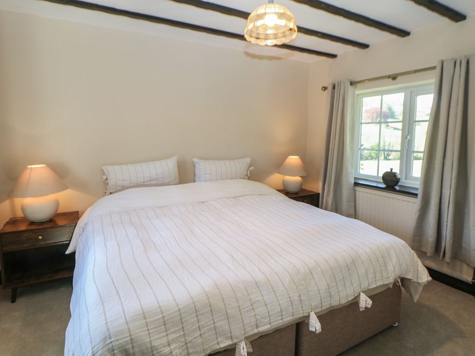 A bedroom with a bed and nightstands at Pine Cottage