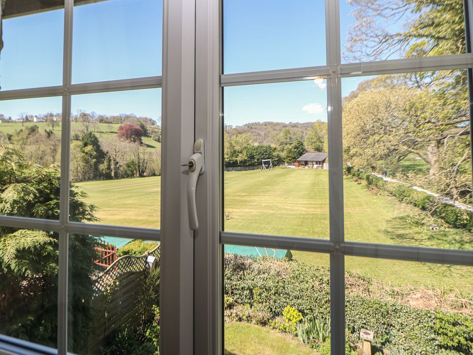 A view from a window showing grass and trees at Pine Cottage