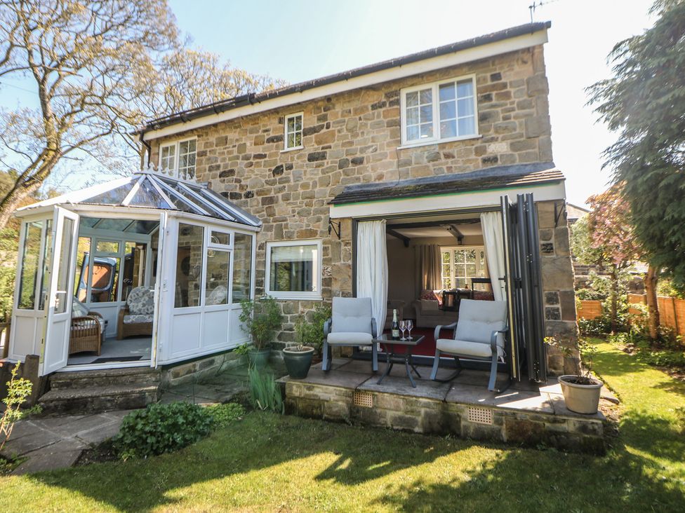A house with a conservatory and garden at Pine Cottage in 