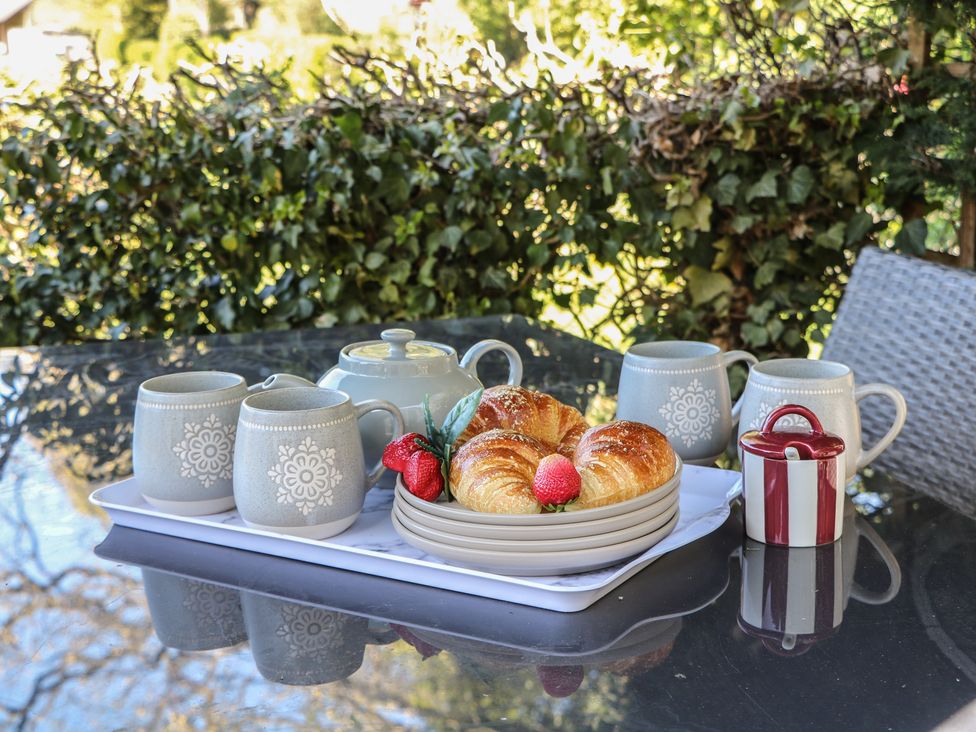 A tea set with croissants and strawberries on a tray at Pine Cottage