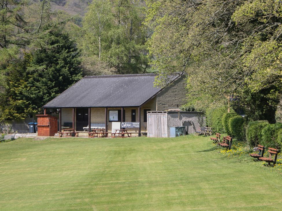 A building surrounded by grass and trees at Pine Cottage 