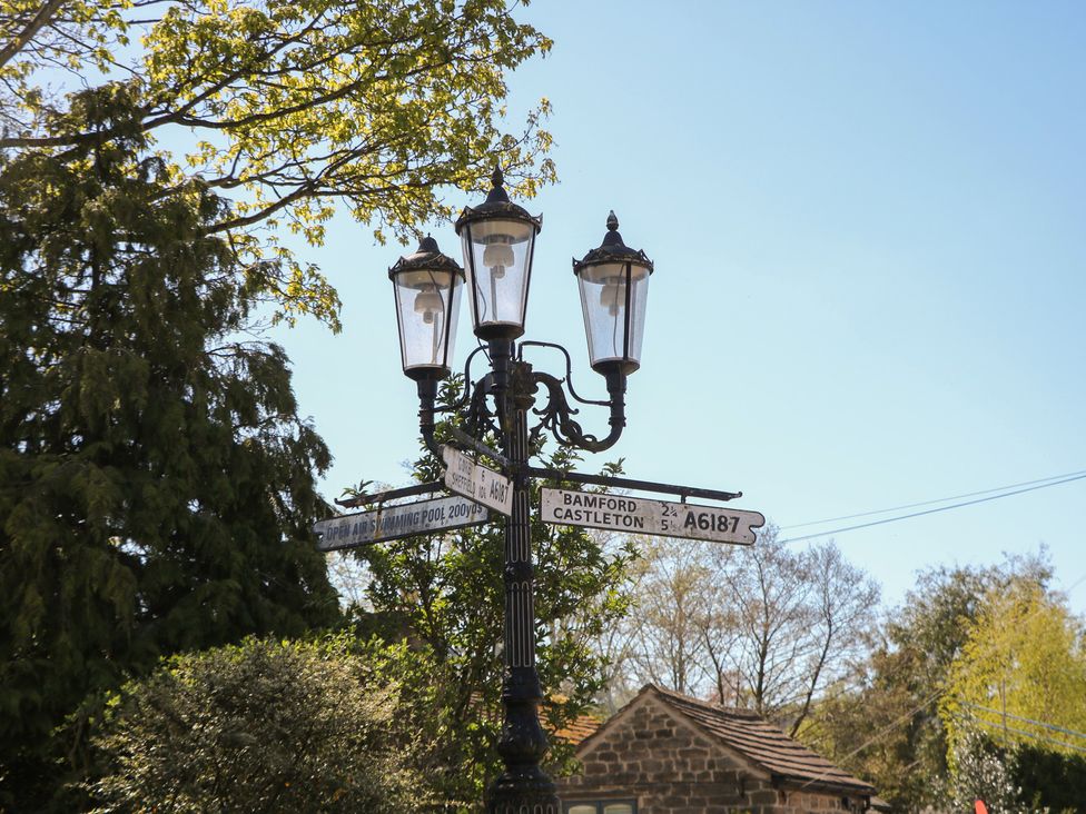 A street sign with directions and a lamp post at Pine Cottage