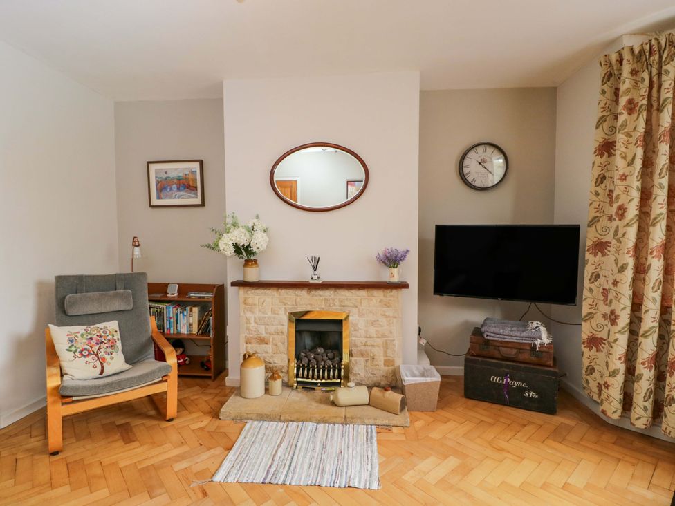 A living room with a fireplace and a television at Highbury in Bath