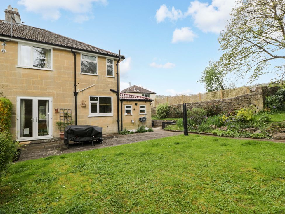 A garden with a house and patio area at Highbury in Bath