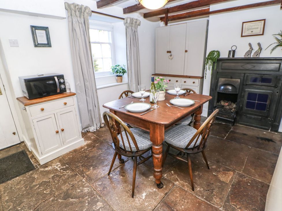 A dining room with a table set for a meal at Englewood Cottage in Hexham