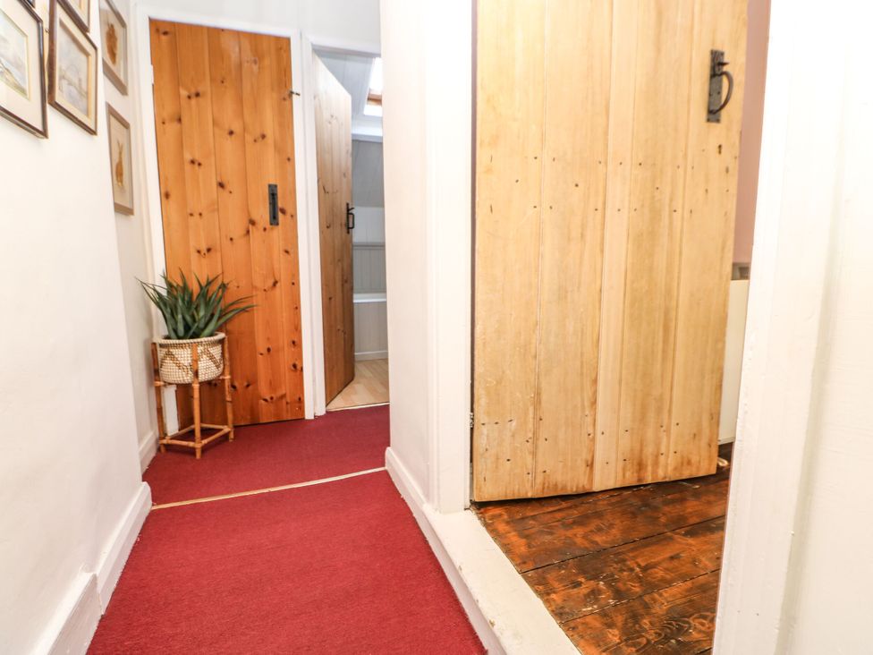 A hallway with doors and a plant at Englewood Cottage in Hexham