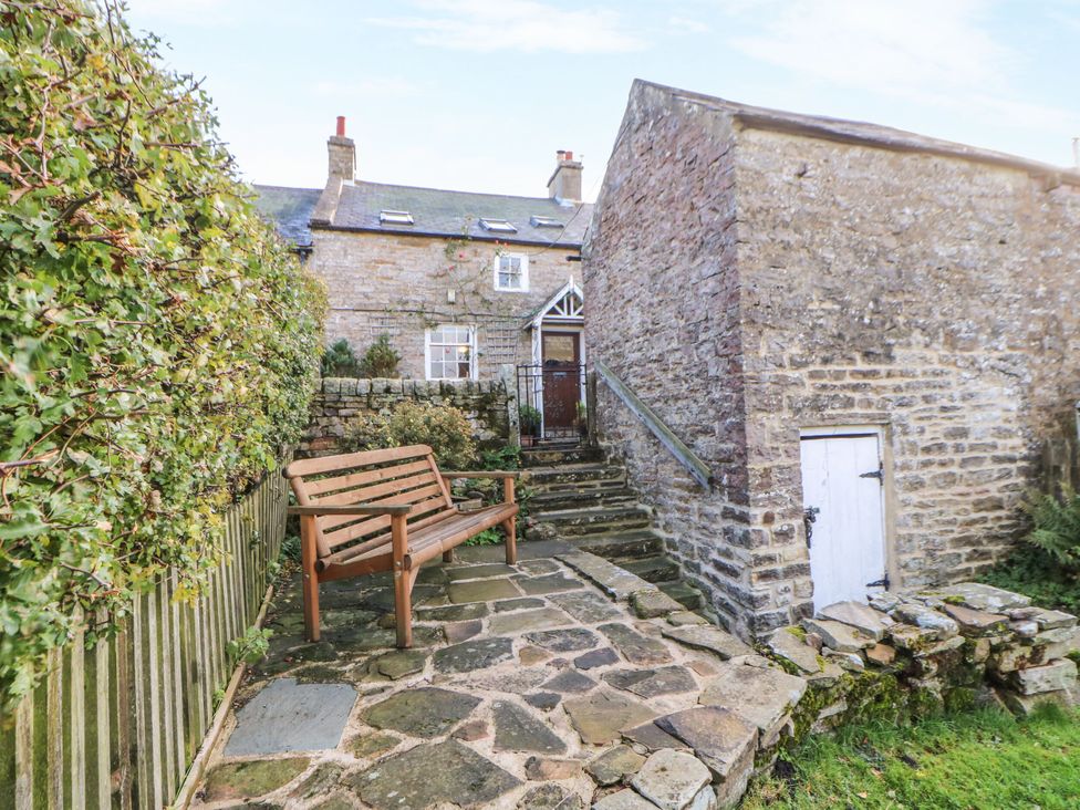 A garden with a bench and stone steps at Englewood Cottage in Hexham
