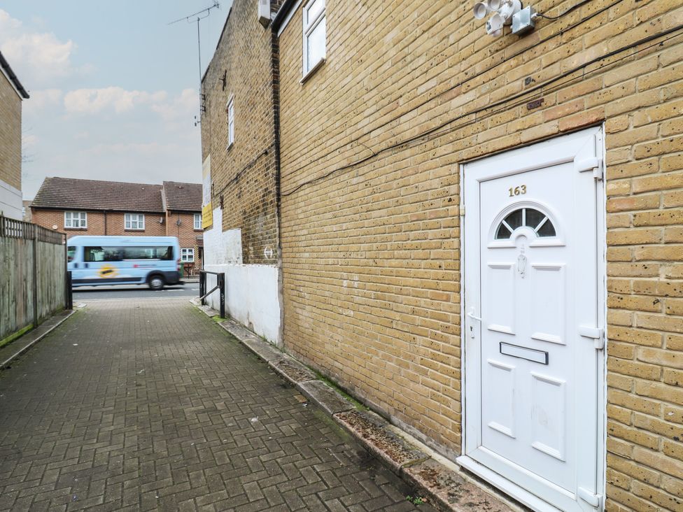An outdoor area with a white door and a bus passing by at Peckhamsbest Suite, London
