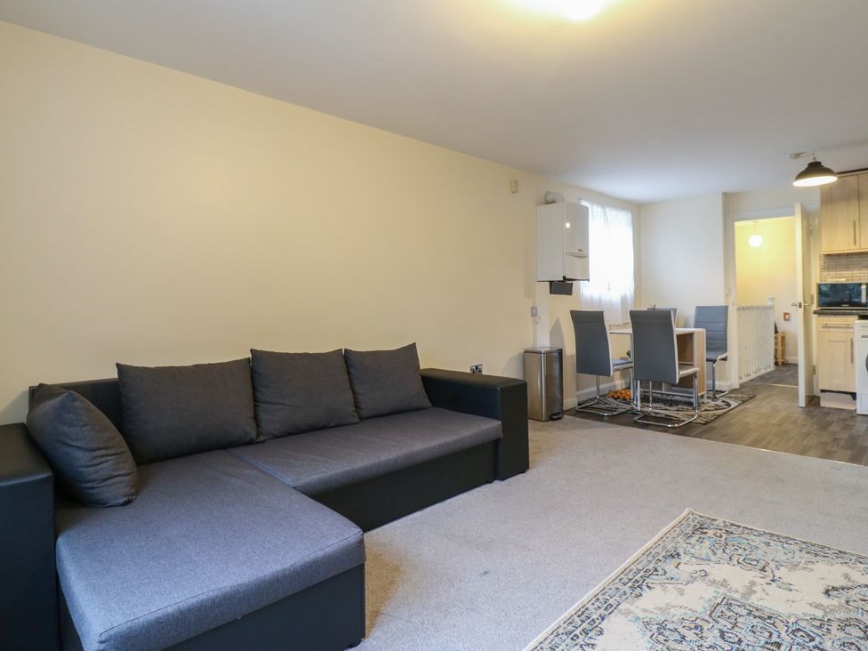 A living room with a sofa and dining area at Peckhamsbest Suite in London