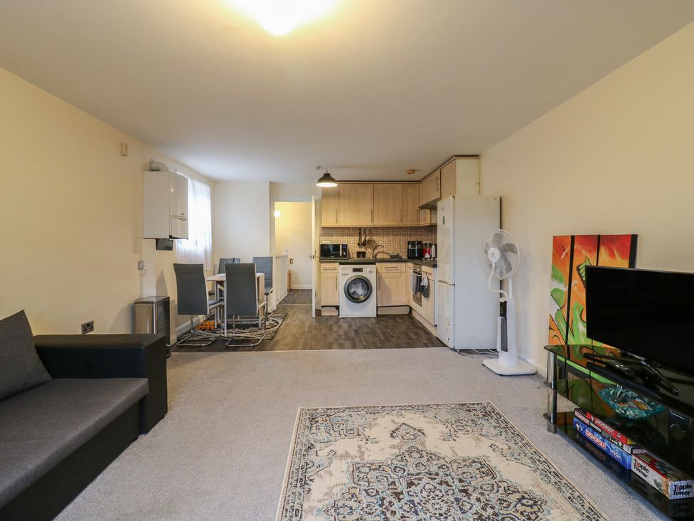 A living room with kitchen appliances and furniture at Peckhamsbest Suite in London
