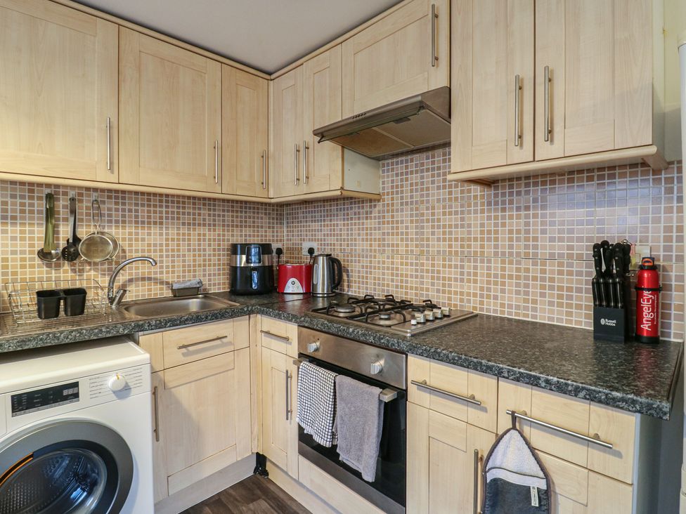 A kitchen with cabinets, sink, and appliances at Peckhamsbest Suite in London