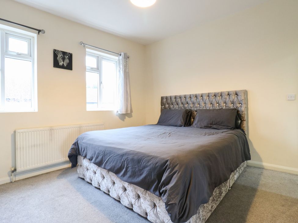 A bedroom with a bed and two windows at Peckhamsbest Suite in London