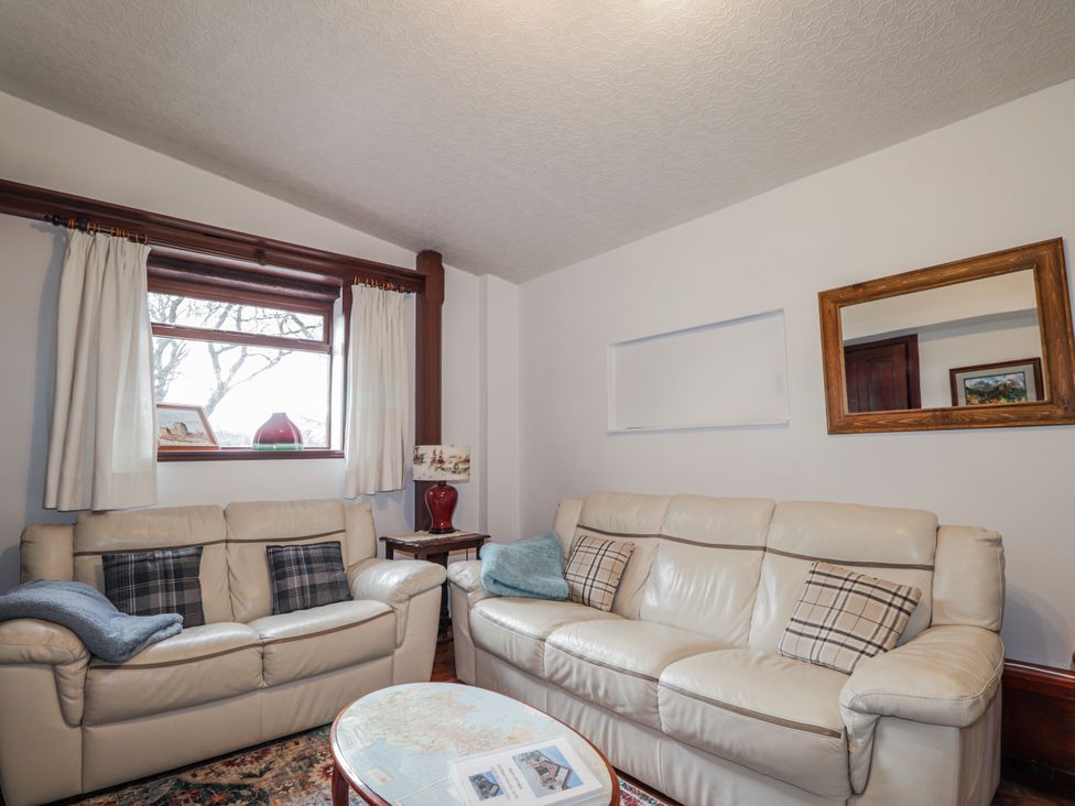 A living room with sofas and a window at Islay Cottage in Kincraig
