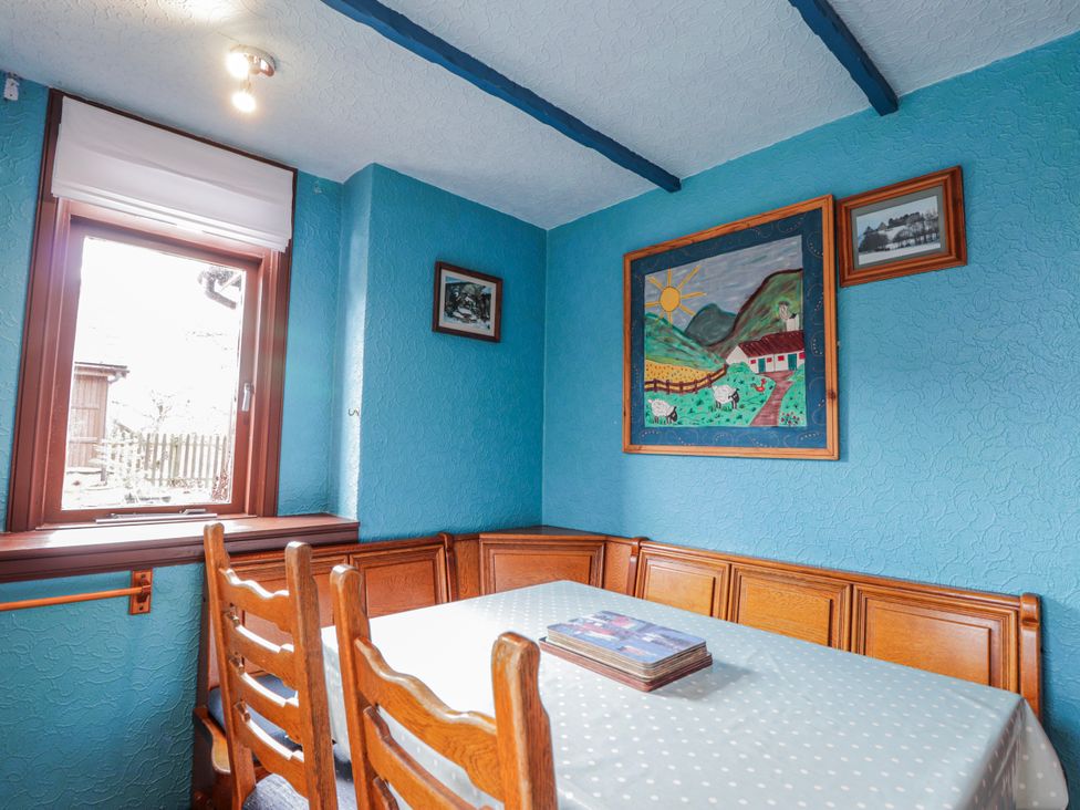 A dining room with a table and chairs at Islay Cottage in Kincraig