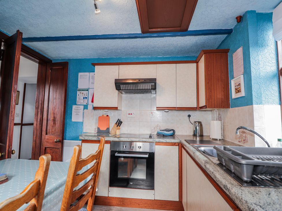 A kitchen with cabinets and appliances at Islay Cottage in Kincraig