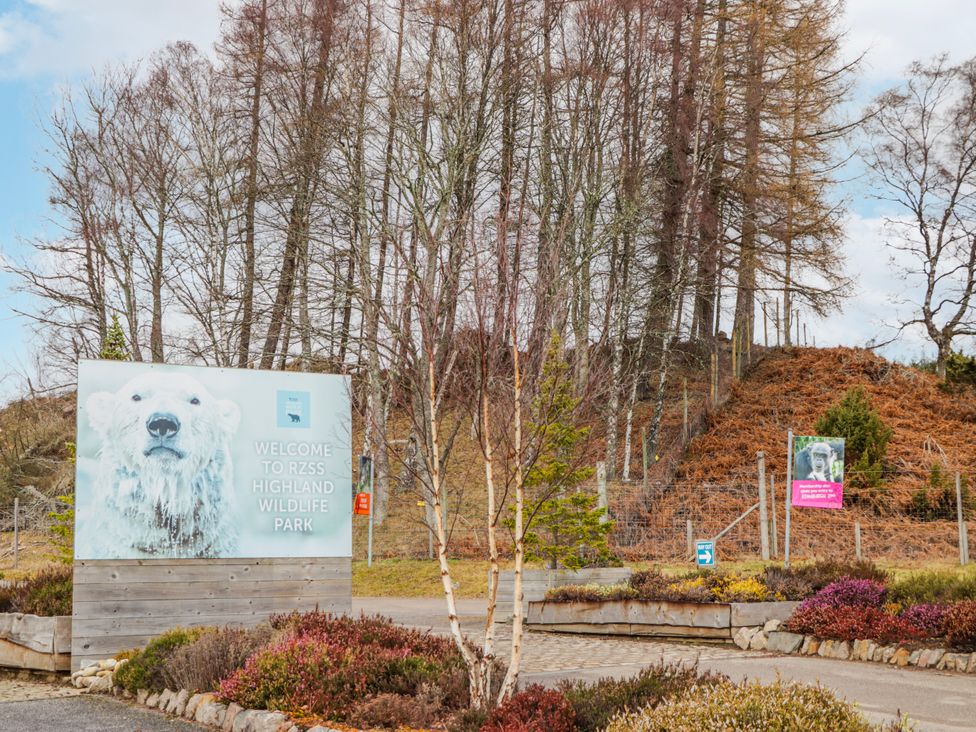 A sign welcoming visitors to RZSS Highland Wildlife Park with trees in the background at Islay Cottage Kincraig