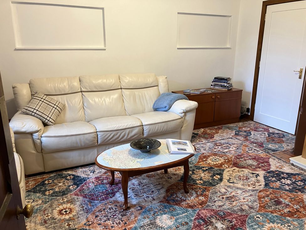A living room with a sofa and coffee table at Islay Cottage in Kincraig