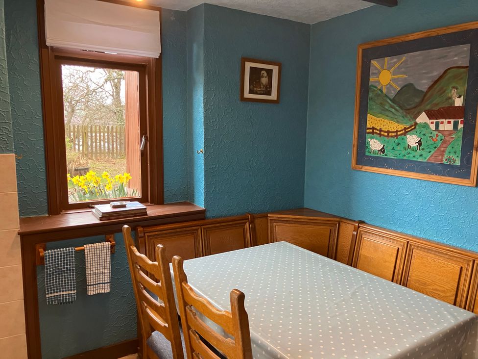 A kitchen with a table and chairs at Islay Cottage Kincraig