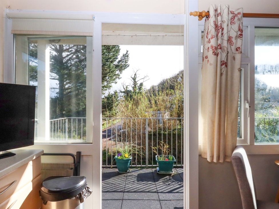 A kitchen view of a balcony with flower pots at Flat 1 Lee Cliff Park in Dawlish Warren
