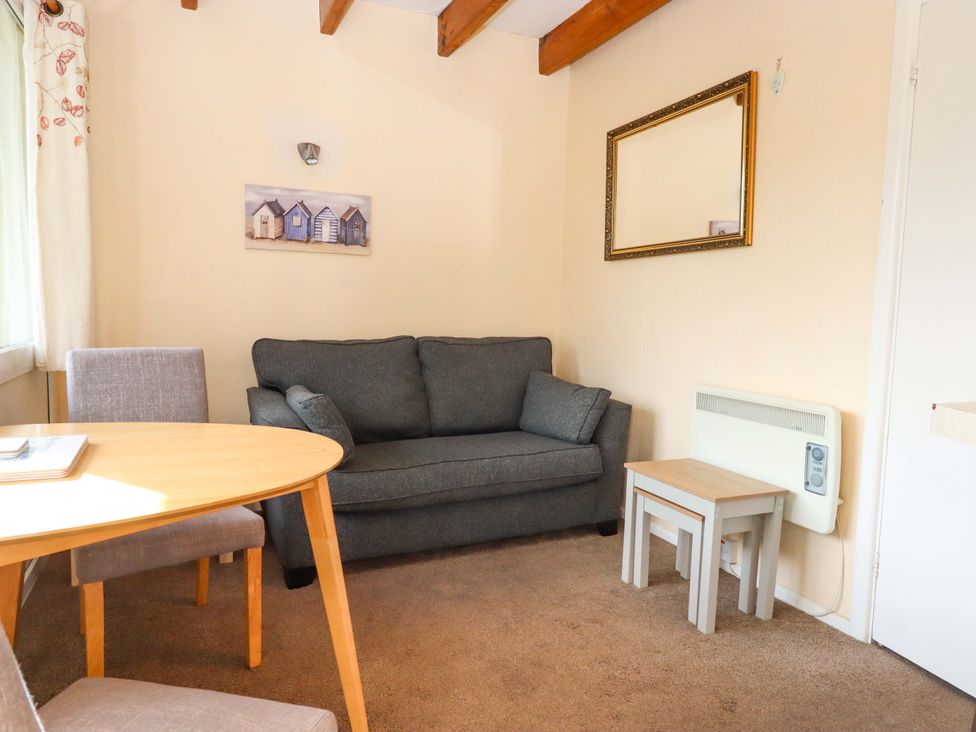 A living room with a sofa and dining table at Flat 1 Lee Cliff Park in Dawlish Warren