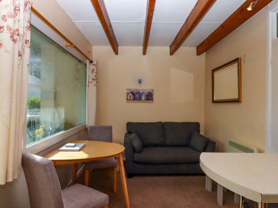 A living room with a sofa and dining table at Flat 1 Lee Cliff Park Dawlish Warren