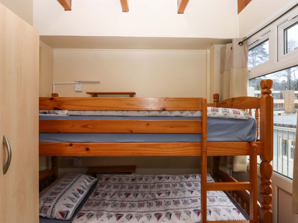 A bedroom with a bunk bed and wardrobe at Flat 1 Lee Cliff Park in Dawlish Warren