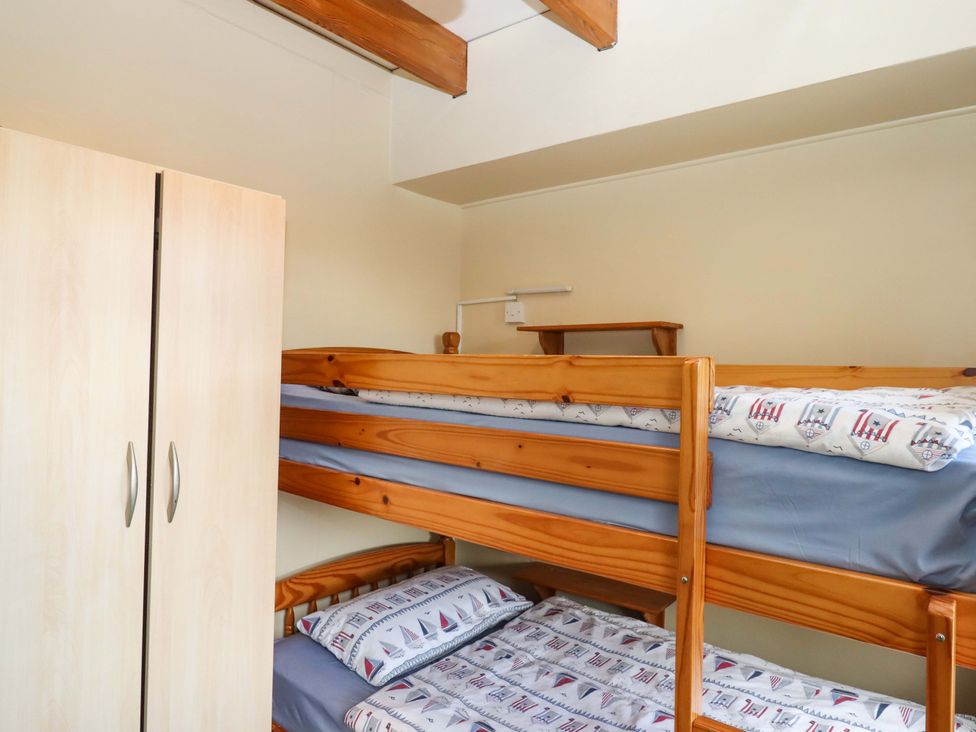 A bedroom with a bunk bed and wardrobe at Flat 1 Lee Cliff Park Dawlish Warren