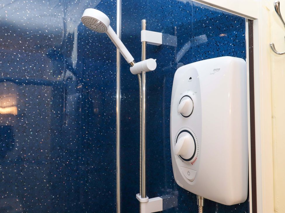 A shower with a wall-mounted showerhead and control valve at Flat 1 Lee Cliff Park Dawlish Warren