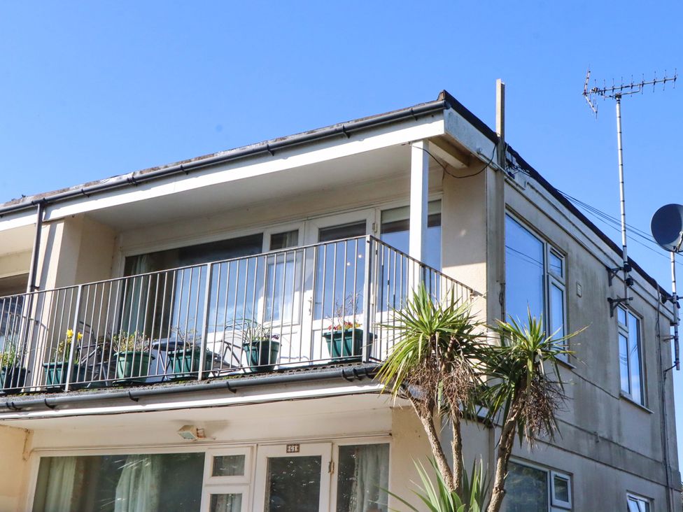 A balcony with potted plants and satellite dish at Flat 1 Lee Cliff Park Dawlish Warren