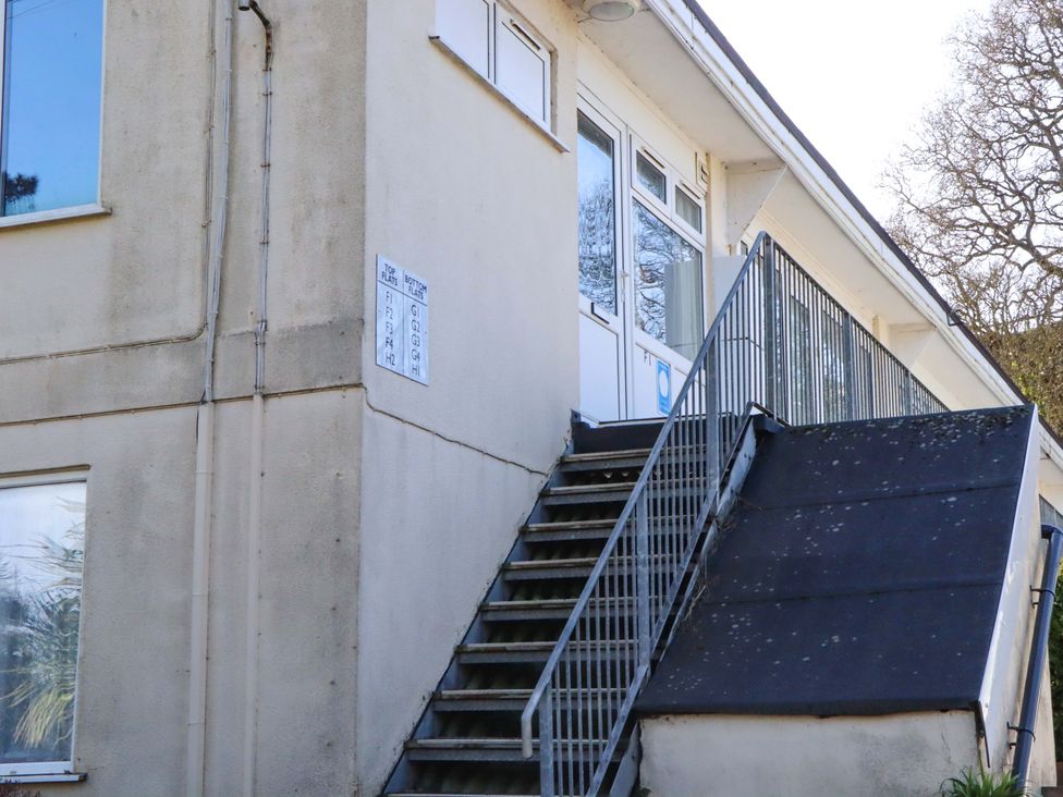 A building with stair access and signage at Flat 1 Lee Cliff Park in Dawlish Warren