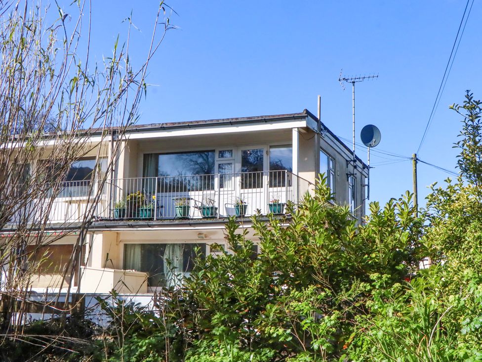 A building with a balcony and satellite dish at Flat 1 Lee Cliff Park Dawlish Warren