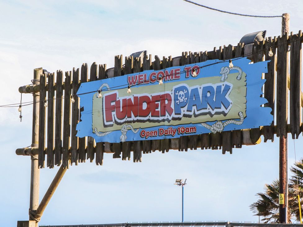 A welcome sign for Funder Park with opening hours at Dawlish Warren