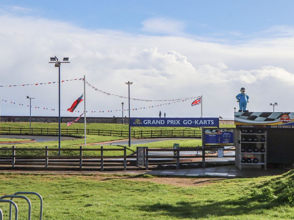 An outdoor go-kart track with flags and a ticket booth at Grand Prix Go-Karts Dawlish Warren