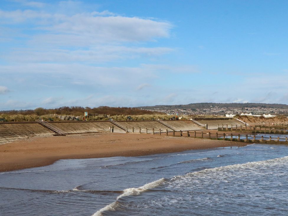 A beach scene with water, sand, and steps at Flat 1 Lee Cliff Park Dawlish Warren