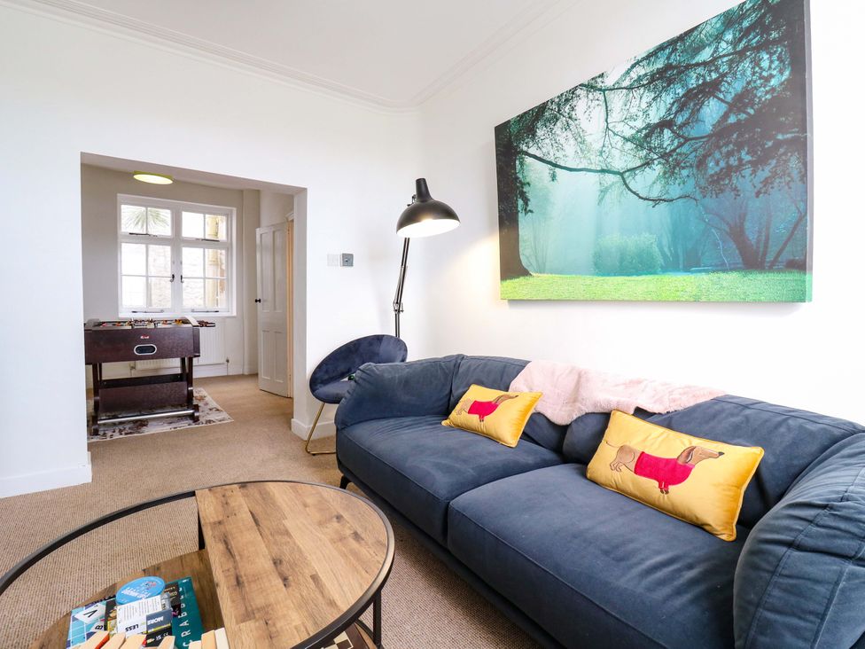 A living room with a blue sofa and coffee table at 7 Athol Terrace 