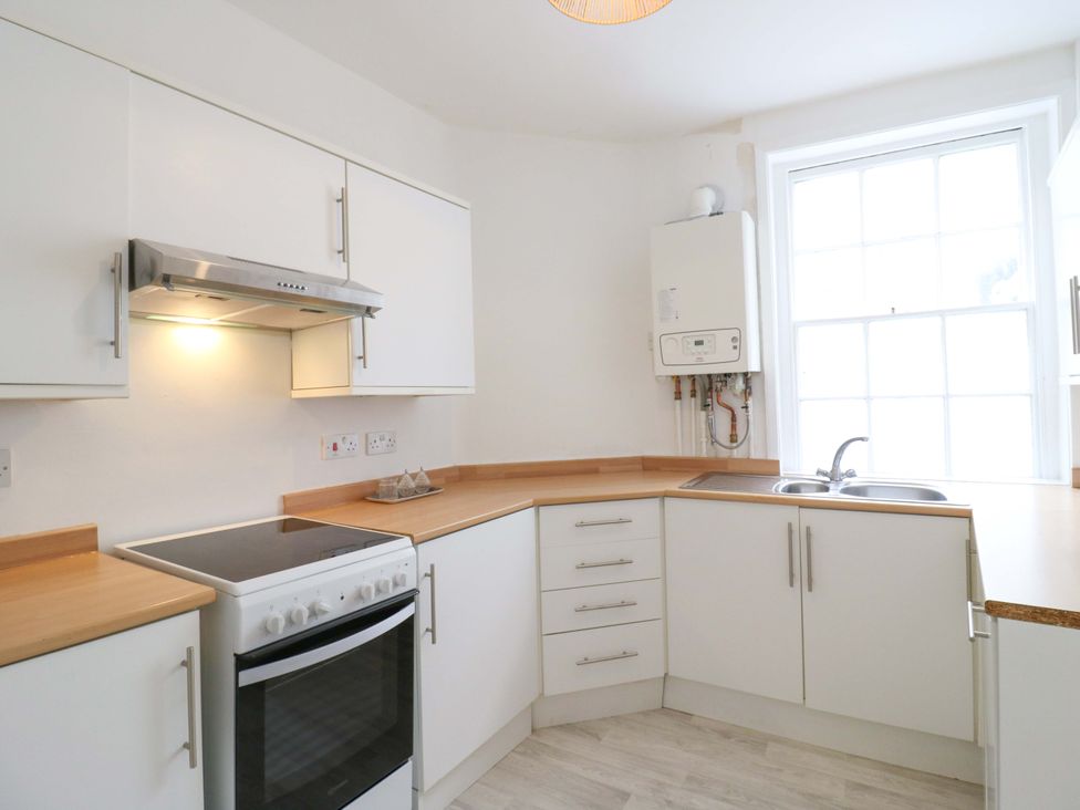 A kitchen featuring a stove, sink, and extractor fan at 7 Athol Terrace 