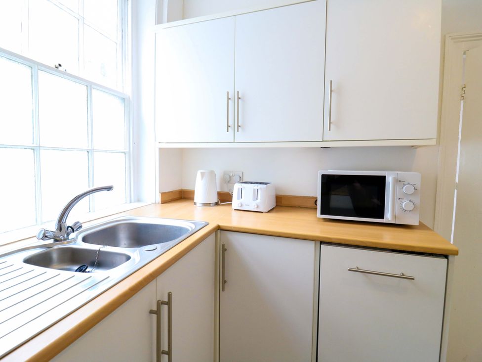 A kitchen with a sink, microwave, toaster and kettle at 7 Athol Terrace