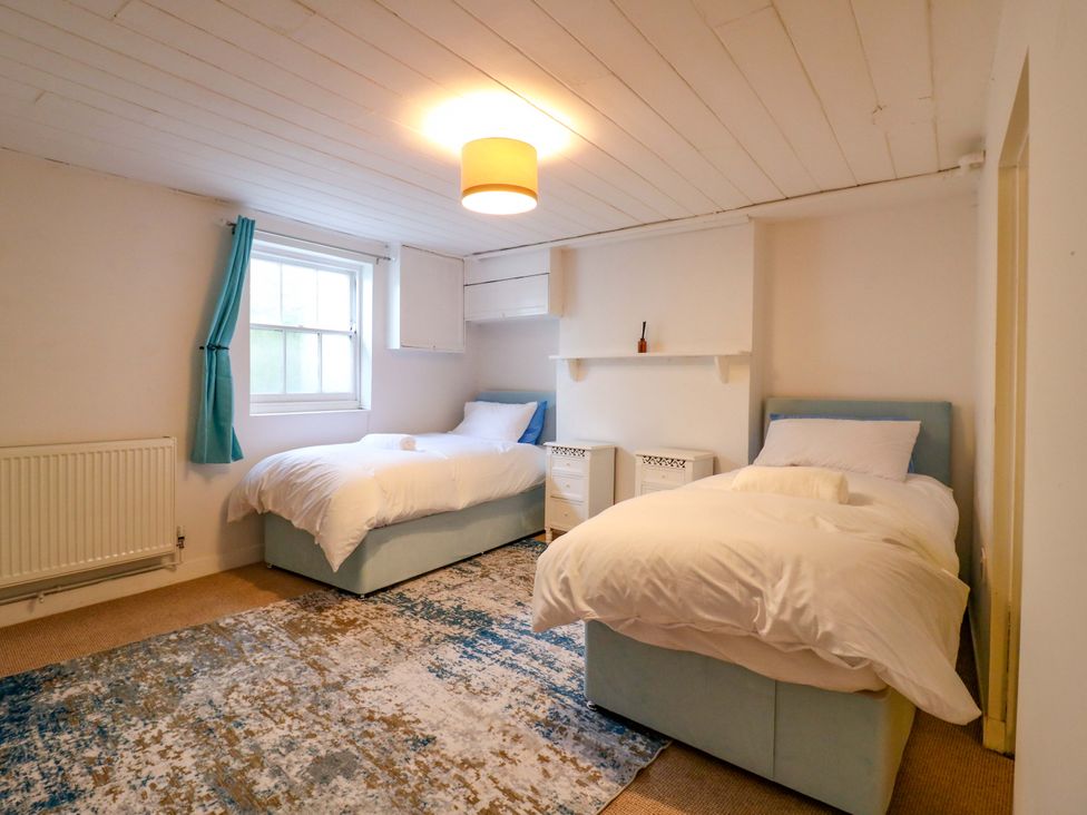 A bedroom with two beds and a window at 7 Athol Terrace