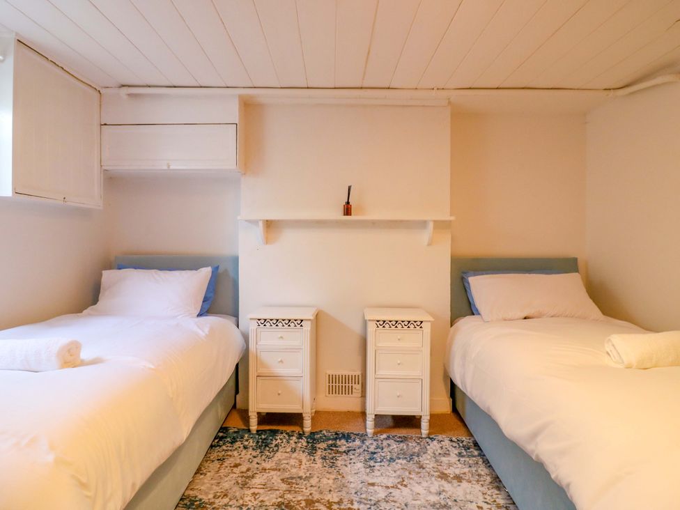 A bedroom with two beds and a nightstand at 7 Athol Terrace