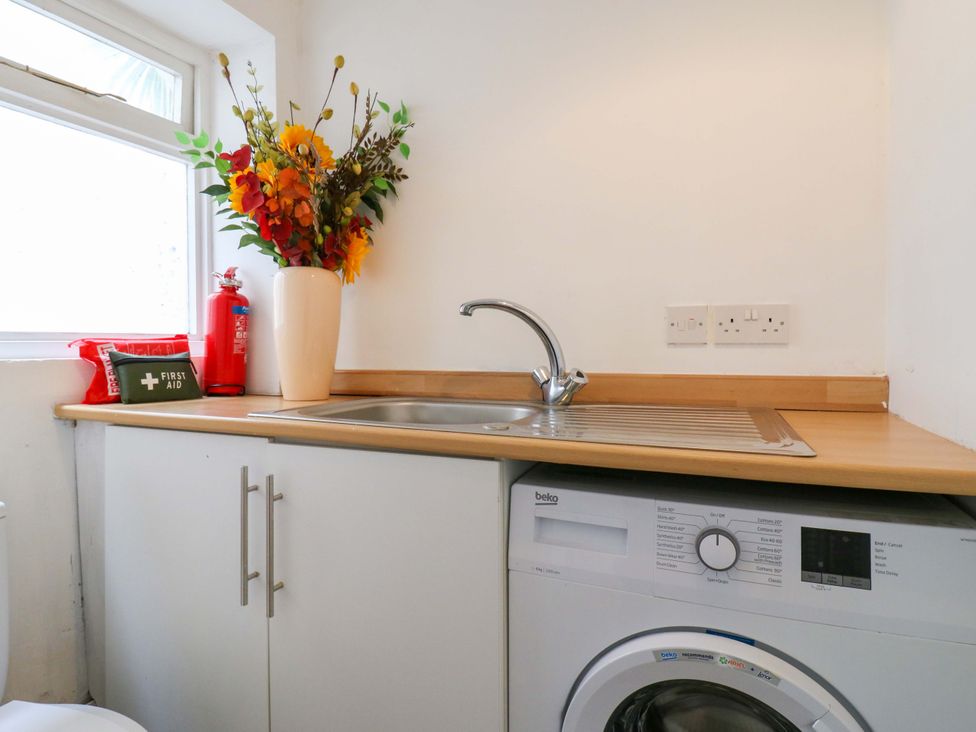 A laundry room with a washing machine and sink at 7 Athol Terrace