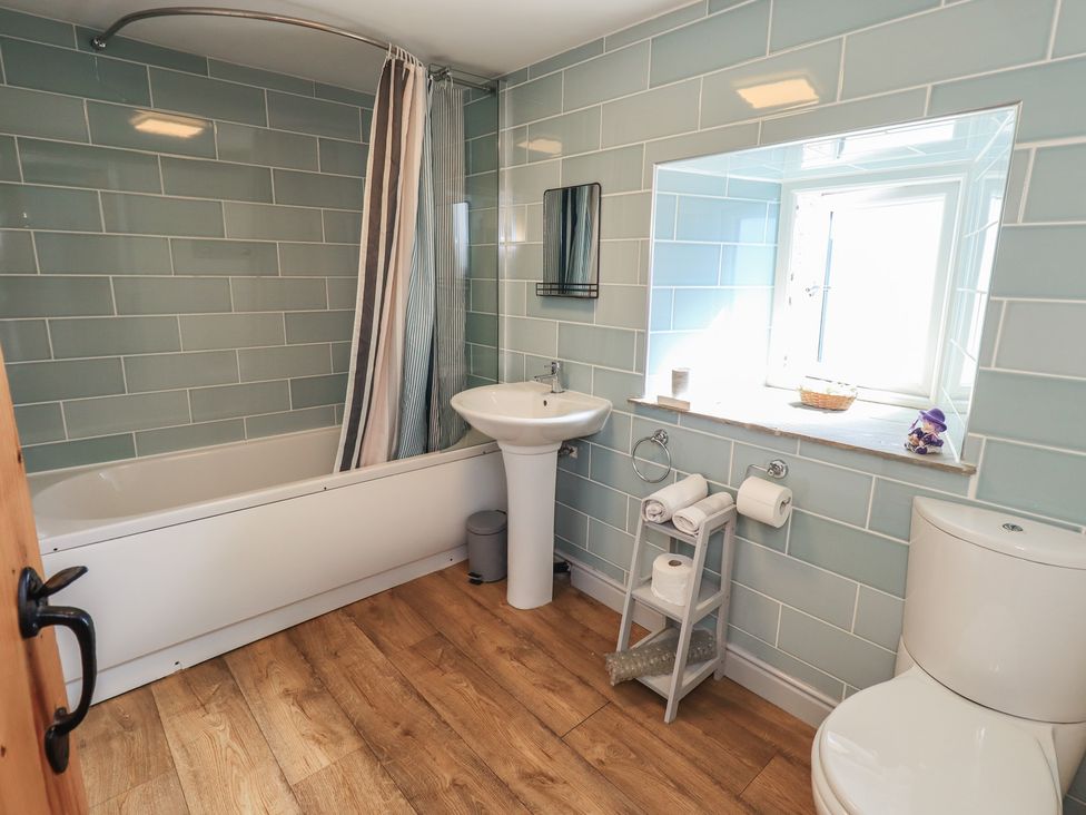 A bathroom with a bathtub and sink at 4 Oak Cottages in Lancaster